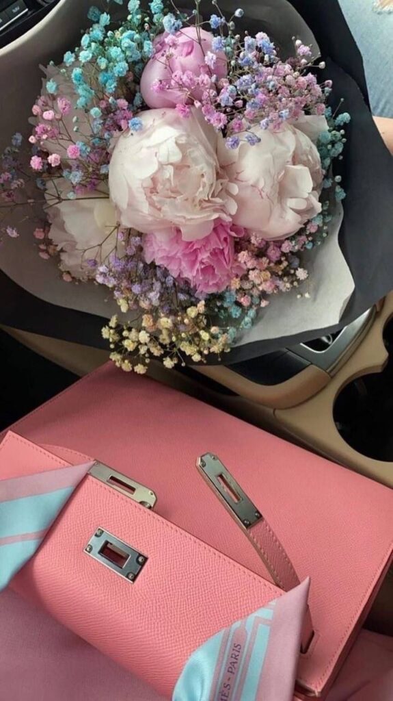 Pink Mini Kelly With Silver Hardware next to bouquet of flowers