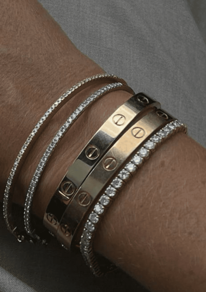 cartier love bracelet stacked with diamond tennis bracelet displayed on a hand