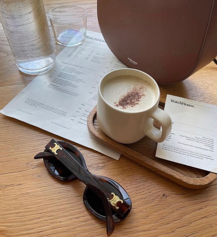 Celine Triomphe Tortoise Sunglasses on table next to coffee and celine brown handbag