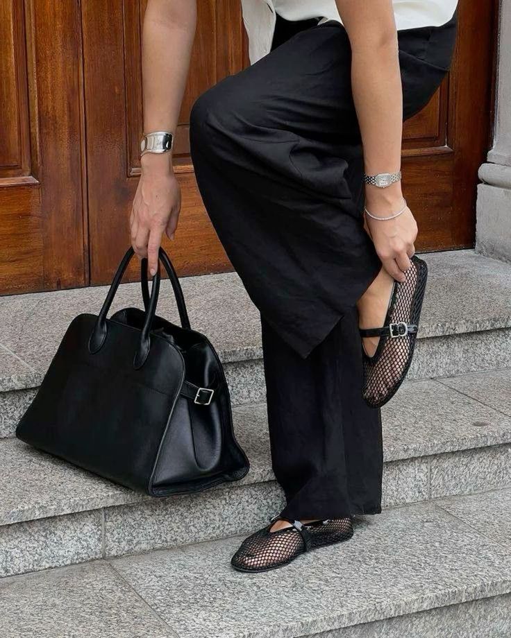 Girl wearing the the row margaux bag and khaite fishnet ballet flats