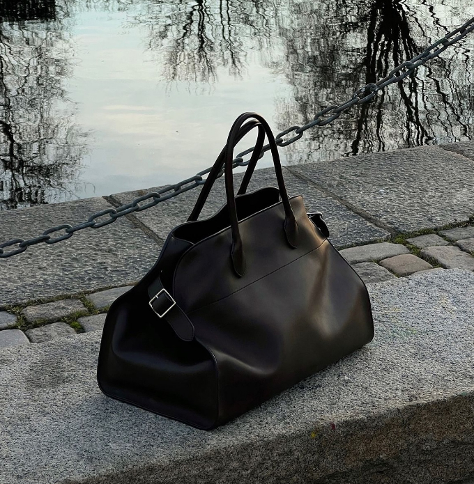 the row margaux leather brown 17 bag on a ledge