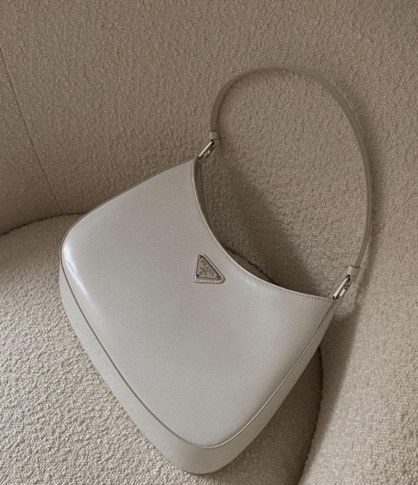 White Prada Cleo bag on a boucle couch