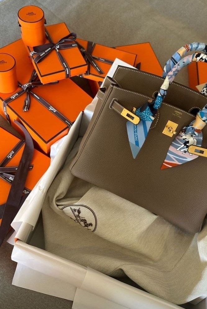 Hermes Birkin 30 in etoupe bag with gold hardware and hermes orange boxes in a pile next to it